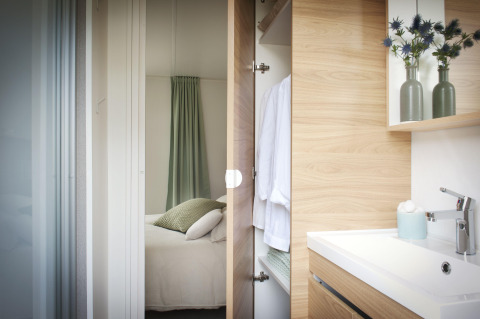 Moderne slaapkamer en badkamer in Stacaravan Premium+ op Flower Camping Au Bois Des Biches in Frankrijk.