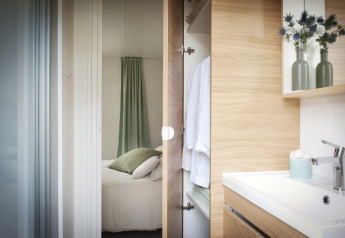 Modernes Schlafzimmer und Badezimmer im Stacaravan Premium+ auf Flower Camping Au Bois Des Biches in Frankreich.