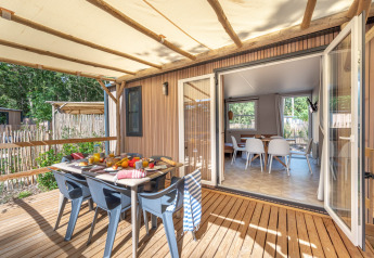 Zona pranzo esterna su terrazza allo Stacaravan Garden, Flower Camping Au Bois Des Biches, Francia, giornata soleggiata.