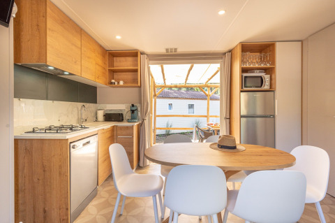 Moderne keuken en eetruimte in Stacaravan Garden bij Flower Camping Au Bois Des Biches in Frankrijk, zicht op terras.