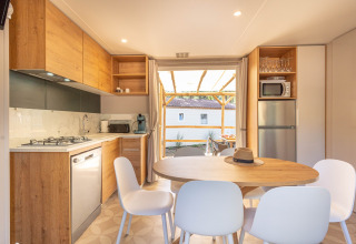 Moderne keuken en eetruimte in Stacaravan Garden bij Flower Camping Au Bois Des Biches in Frankrijk, zicht op terras.