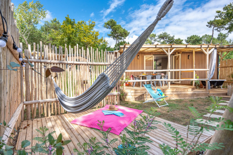 Gezellige tuinchalet met hangmat en zonneterras bij Flower Camping Au Bois Des Biches in Frankrijk.