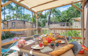 Terrasse extérieure couverte avec table de petit déjeuner au Stacaravan Garden, Flower Camping Au Bois Des Biches, France.