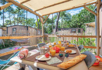 Overdekt terras met ontbijttafel bij Stacaravan Garden, Flower Camping Au Bois Des Biches in Frankrijk.