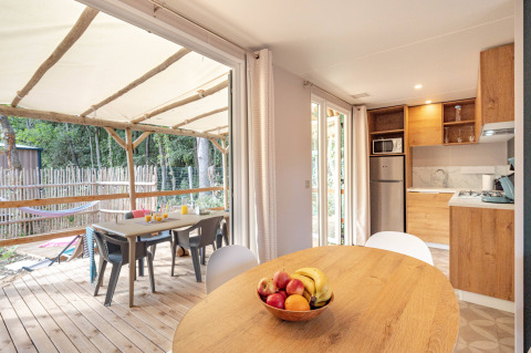 Vista interna di cucina e terrazza allo Stacaravan Garden, Flower Camping Au Bois Des Biches, Francia.