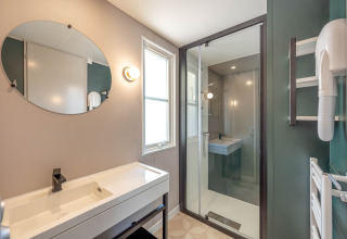 Salle de bain moderne avec douche, grand miroir et lavabo au Stacaravan Garden, Flower Camping Au Bois Des Biches.