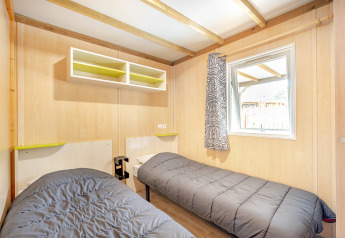 Lichte slaapkamer in Cottage Garden bij Flower Camping Au Bois Des Biches in Frankrijk met twee éénpersoonsbedden.