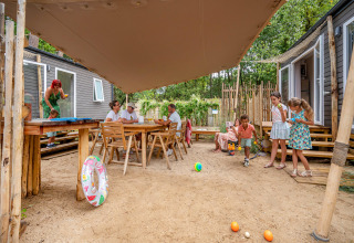 Famiglie si rilassano e giocano all'aperto presso una Stacaravan Tribu al Flower Camping Au Bois Des Biches, Francia.