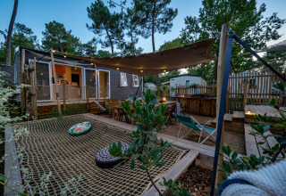 Outdoor deck at Stacaravan Tribu, Flower Camping Au Bois Des Biches, France, with hammock net and seating.