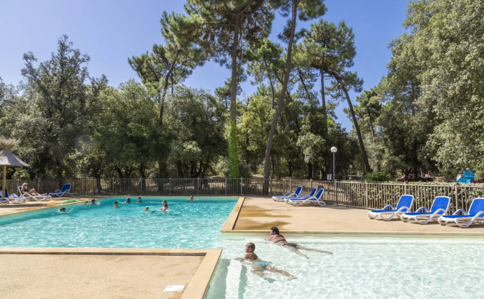 Zwembad met gasten en ligstoelen bij Tente Lodge Confort zonder sanitair op Flower Camping Monplaisir.