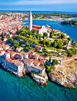 Veduta aerea di una storica città costiera vicino a Pola in Istria, Croazia, circondata da mare blu e verde.