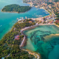 Vista aerea di Pula, Istria, Croazia, con acque turchesi, vegetazione rigogliosa e un vivace porto turistico.