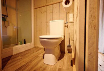 Bagno in tenda safari al campeggio 't Geuldal nei Paesi Bassi, con wc, doccia e pavimento in legno.