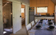 Intérieur de la tente safari « Ranger » au camping 't Geuldal, avec coin repas et cuisine aux Pays-Bas.