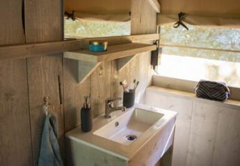 Rustic wooden bathroom with sink and shelf in a Safari tent at Campsite 't Geuldal, Netherlands.