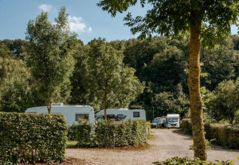 Wohnwagen und Bäume am Safari Trekking-Zelt auf dem Campingplatz 't Geuldal in den Niederlanden.