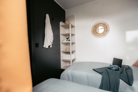 Modern lodge-slaapkamer in Limburg Lodge op Camping 't Geuldal, Nederland, met twee eenpersoonsbedden.
