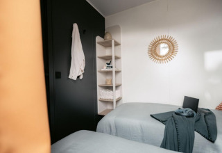 Modern lodge-slaapkamer in Limburg Lodge op Camping 't Geuldal, Nederland, met twee eenpersoonsbedden.