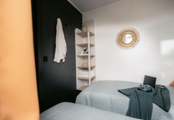 Modern lodge bedroom at Limburg Lodge, Campsite 't Geuldal, Netherlands, with twin beds and stylish decor.