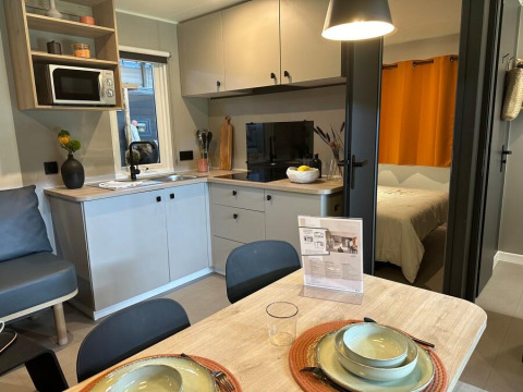 Moderne keuken en eethoek in Limburg Lodge op camping 't Geuldal, Nederland, met zicht op de slaapkamer.