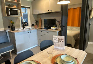 Moderne keuken en eethoek in Limburg Lodge op camping 't Geuldal, Nederland, met zicht op de slaapkamer.