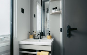 Bagno moderno e compatto con tocchi gialli alla Limburg Lodge XL, campeggio 't Geuldal nei Paesi Bassi.