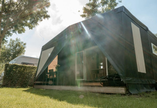 Safaritent 'Coco Sweet' op Camping 't Geuldal in Nederland met veranda en groene tuin eromheen.