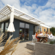 En familie sidder og hygger sig udenfor en Dune Lodge Family ved Camping Zonneweelde i Holland.
