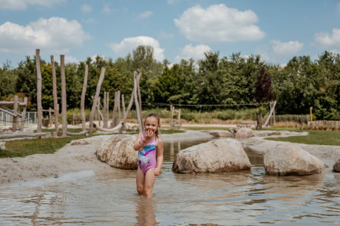 Una bambina gioca nell’acqua bassa al campeggio 't Geuldal nel Limburgo, Paesi Bassi.