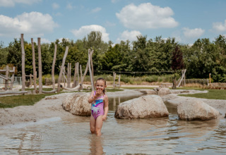 Una bambina gioca nell’acqua bassa al campeggio 't Geuldal nel Limburgo, Paesi Bassi.