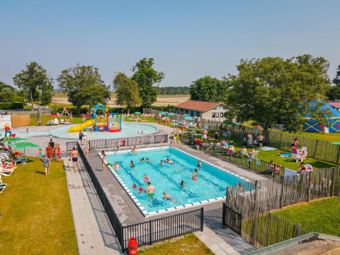 Foto de una piscina al aire libre con familias, área de juegos y césped en un alojamiento glamping.
