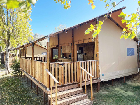 Tenda safari Glamping Lodge PREMIUM in legno e tessuto, con veranda, immersa nella natura.