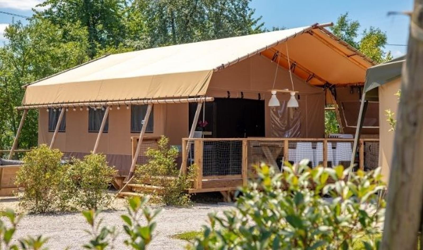 Safaritent Glamping Lodge PREMIUM RIVER 38m op camping Le Val de Cesse, omgeven door natuur.
