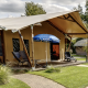 Foto exterior de una tienda de safari de lujo con terraza, tumbonas y sombrilla en un camping verde
