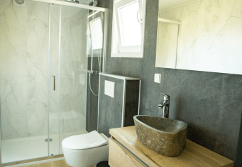 Modernes Badezimmer mit steinernem Waschbecken und Duschkabine in der Heuvelrug Cottage, De Thijmse Berg.