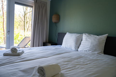 Chambre lumineuse au Heuvelrug Cottage, De Thijmse Berg, Pays-Bas, avec serviettes fraîches et terrasse.