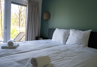 Chambre lumineuse au Heuvelrug Cottage, De Thijmse Berg, Pays-Bas, avec serviettes fraîches et terrasse.