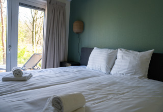 Chambre lumineuse au Heuvelrug Cottage, De Thijmse Berg, Pays-Bas, avec serviettes fraîches et terrasse.