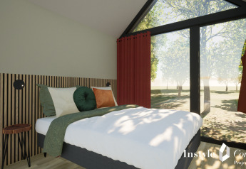 Chambre à Cosy Lodge du Camping Si-Es-An aux Pays-Bas avec grandes fenêtres et vue sur la forêt.