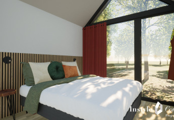 Chambre moderne à Cosy Lodge, Camping Si-Es-An, Pays-Bas, avec grandes fenêtres donnant sur la forêt.