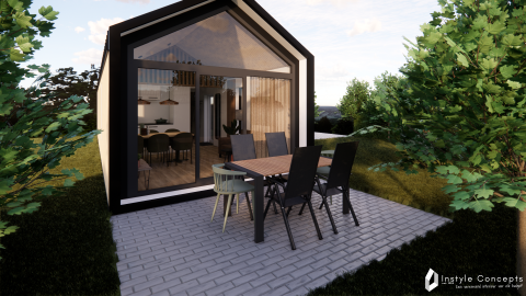 Udendørs spiseområde foran Reestdal lodge med store vinduer på Camping Si-Es-An i Holland, omgivet af træer.