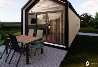 Espace repas extérieur devant la Reestdal lodge au Camping Si-Es-An, entouré de verdure aux Pays-Bas.