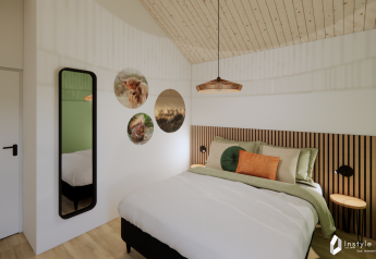 Modern bedroom at Reestdal lodge, Camping Si-Es-An, Netherlands, with stylish decor and wood ceiling panels.