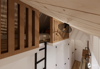 Intérieur du lodge Reestdal au Camping Si-Es-An, avec lit mezzanine, échelle et décor en bois.