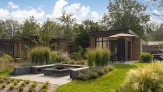 Moderne Cannenburch Deluxe met Hottub Lodge mit Terrasse, Garten und stilvollem Außenbereich bei Sonnenschein.