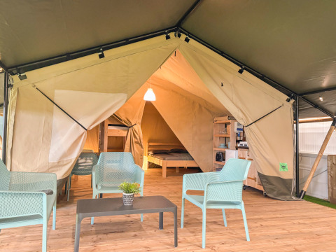 Indretning af en safaritelt med moderne møbler og eget toilet på Vestbirk Camping, Danmark.