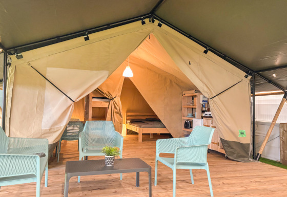 Indretning af en safaritelt med moderne møbler og eget toilet på Vestbirk Camping, Danmark.