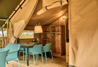 Indretning af Safaritent med moderne faciliteter og spisebord på Vestbirk Camping i Danmark.