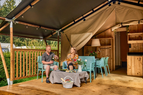 Koppel geniet van een safaritent met sanitair op Vestbirk Camping in Denemarken.