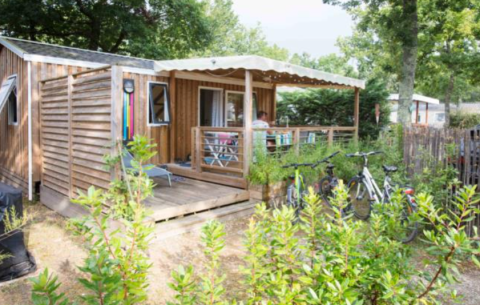 Casa mobile in legno premium al Flower Camping La Canadienne in Francia, con terrazza e biciclette.